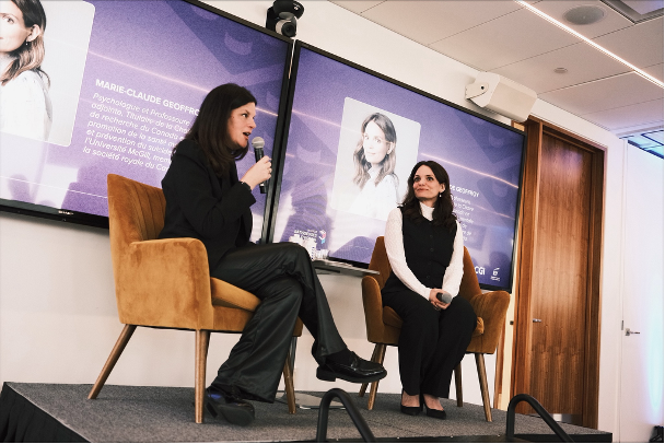 Two women speaking into microphones during panel discussion on mental health